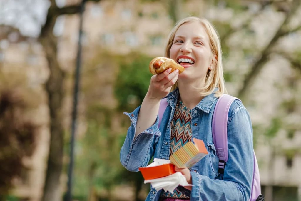 Young woman eating a hotdog snzotnb.width .jpg