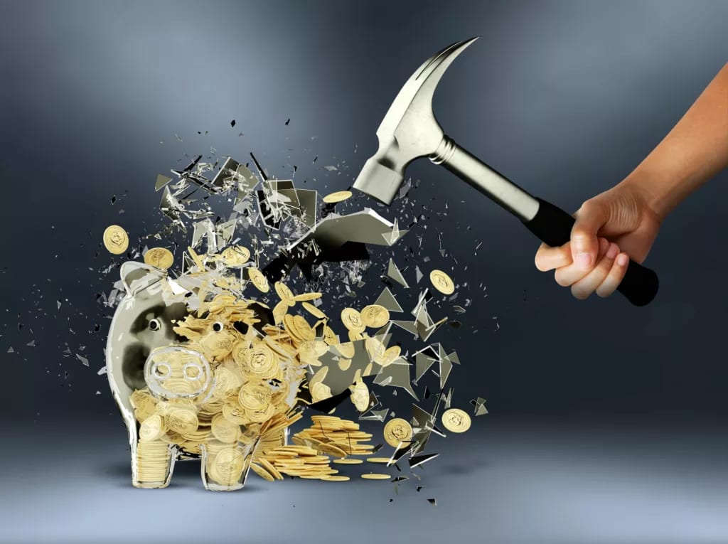 getty images person smashing piggy bank with hammer.jpeg