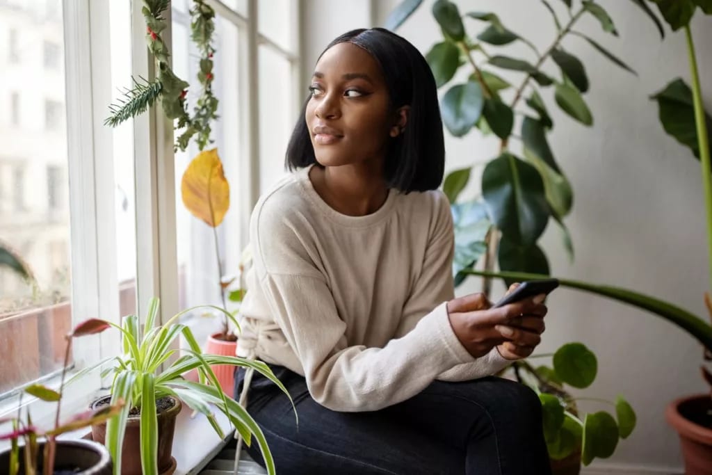 person with phone looking out window ZLNGso.width .jpg