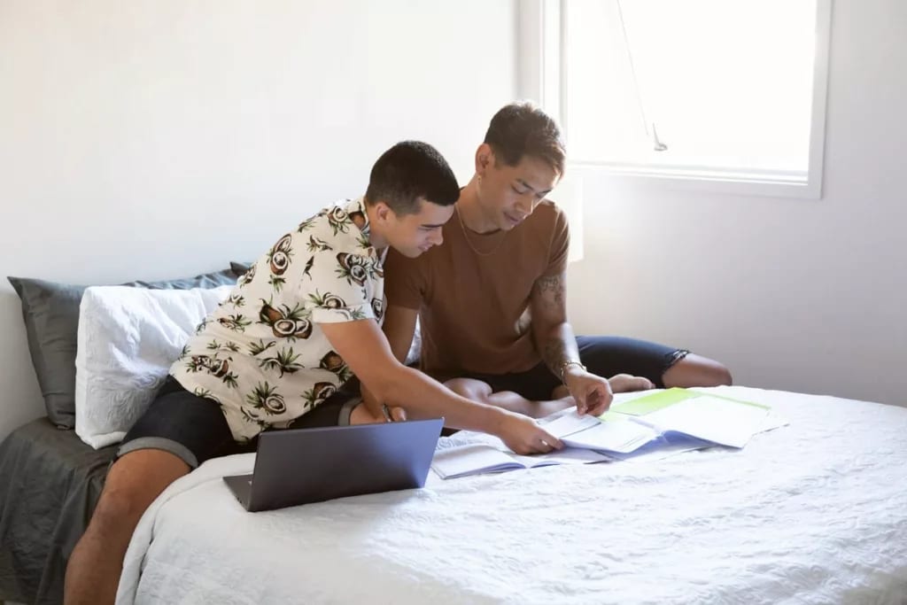 two people sitting on bed with paperwork and .width AejXpPB.jpg