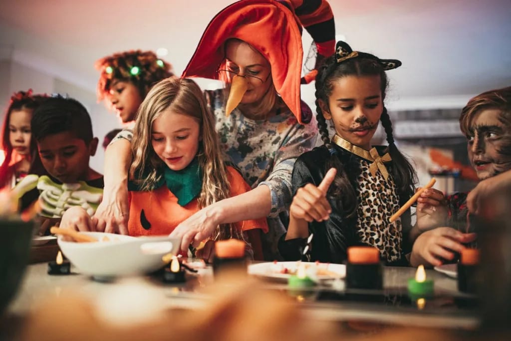Adults and kids doing crafts at a halloween p.width .jpg