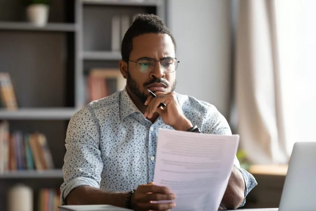 Man looking at documents with unsure expressi.width JzQldPC.jpg