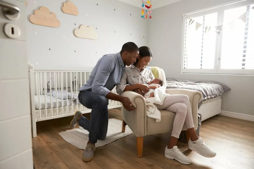 New parents holding baby in the nursery. Tca.width .jpg