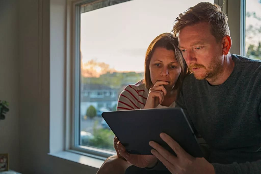 Worried looking couple looking at a tablet to.width omrJse.jpg