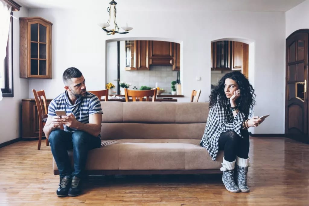 man and woman sitting at opposite ends of a c.width lniJNV.jpg
