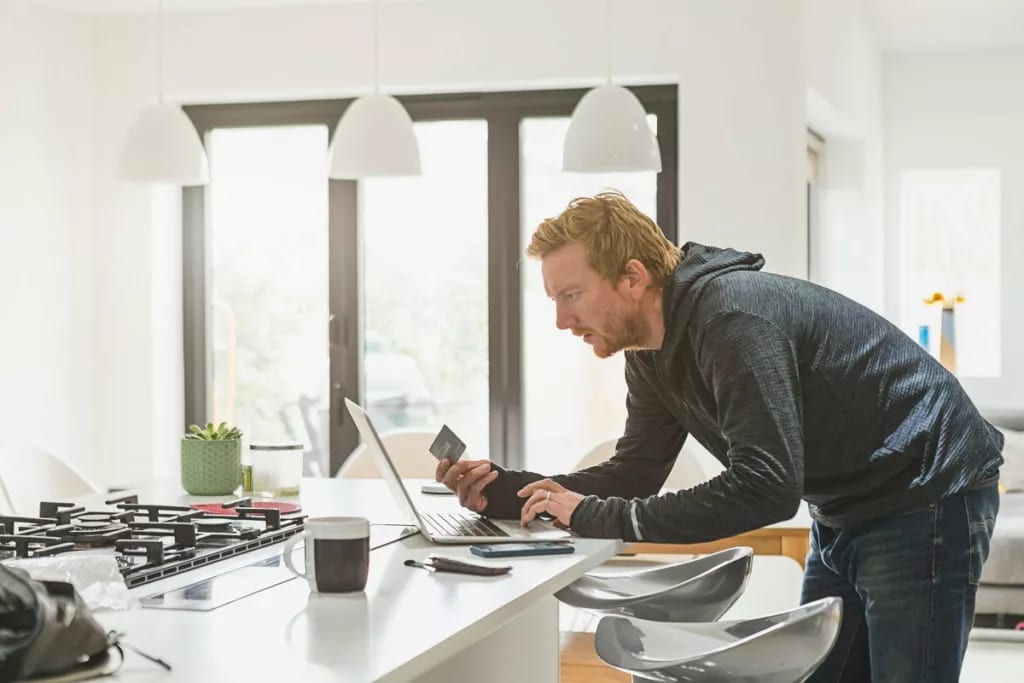 Man holding credit card and using laptop Hlq.width .jpg