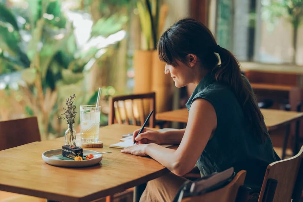 Woman writes letter at cafe table YKfcOac.width .jpg