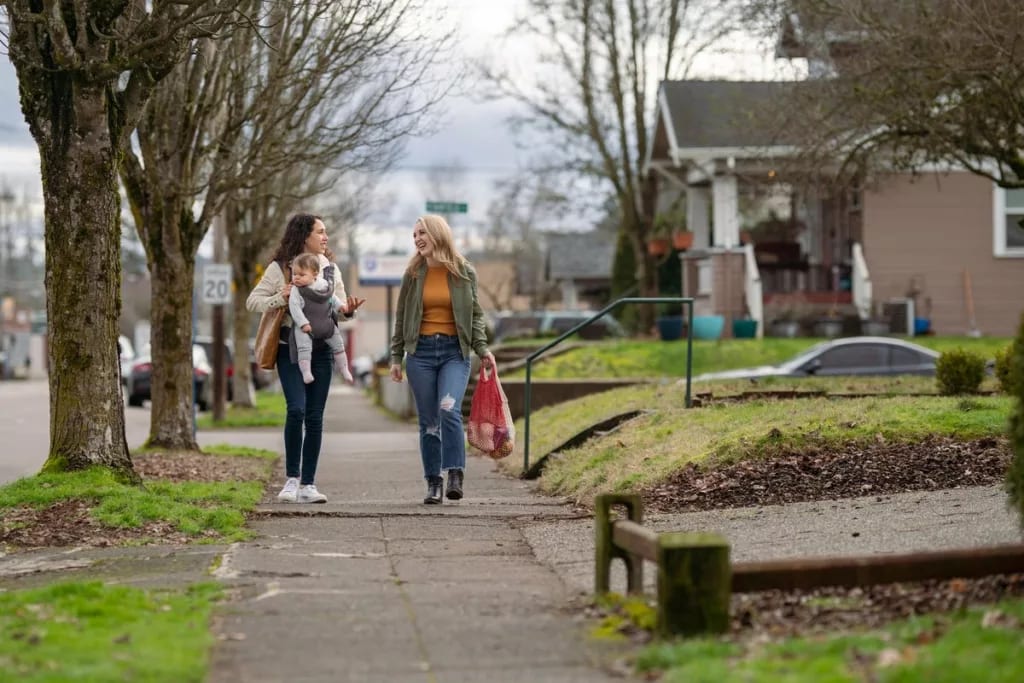 two people and baby walk down residential str.width lGpivdf.jpg