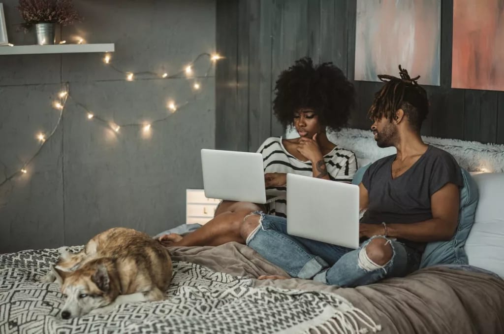 young couple on laptops in bedroom RrGguP.width .jpg