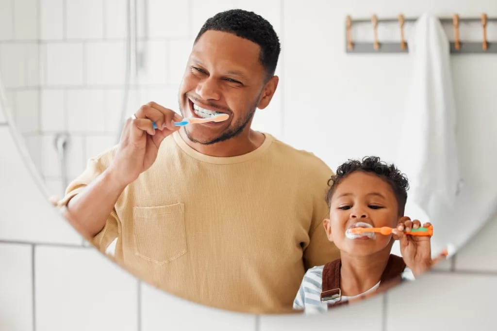 Adult and child brushing their teeth in front.width .jpg