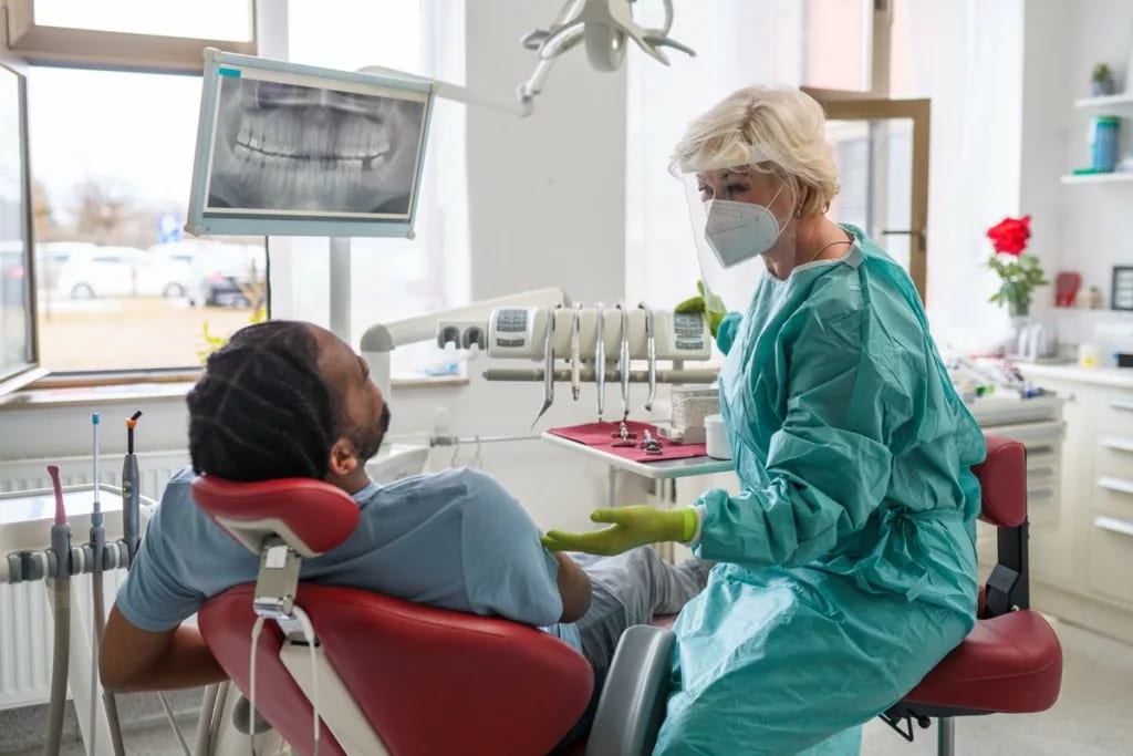Man in chair at dentist office communicating .width .jpg