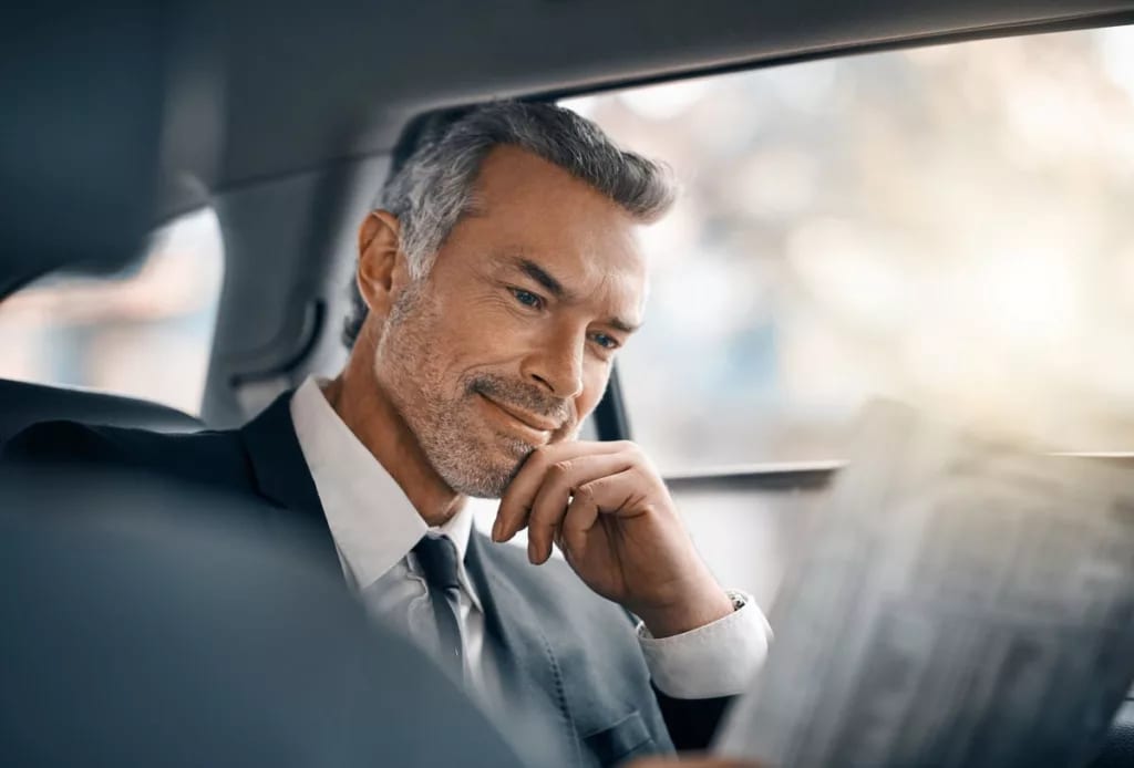 Man sitting in car looking at newspaper wEK.width .jpg