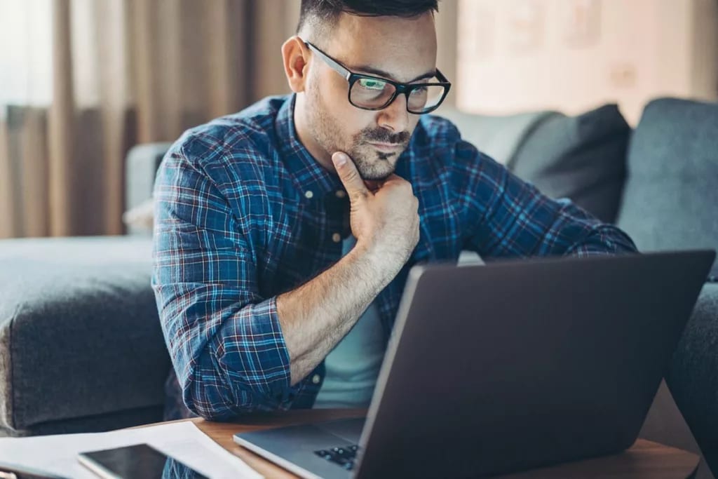 Man with glasses looking at laptop kjgn.width .jpg