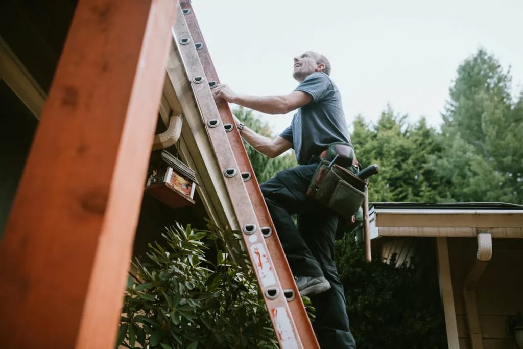 Man with tool belt climbing ladder to roof EJ.width .jpg