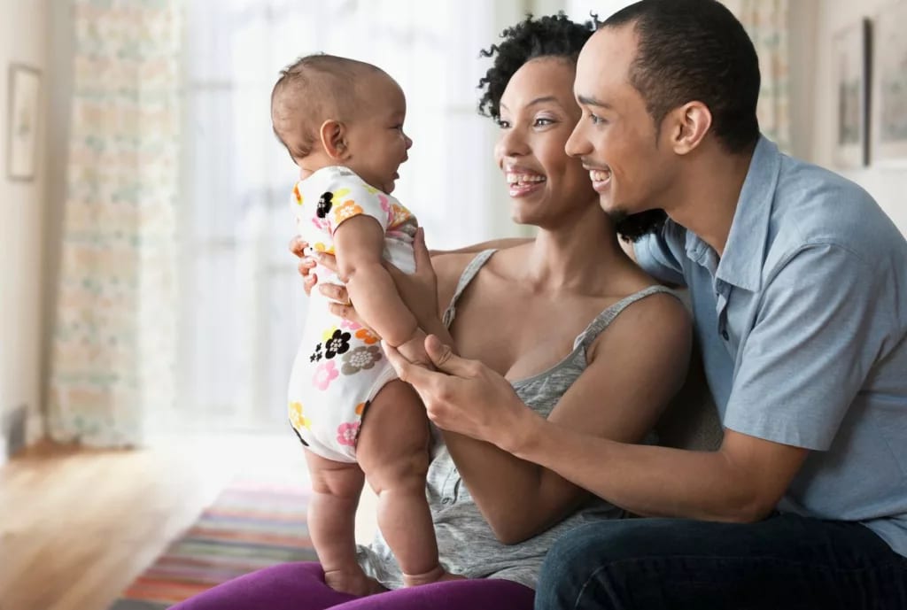 Parents smiling at infant JlkN.width .jpg