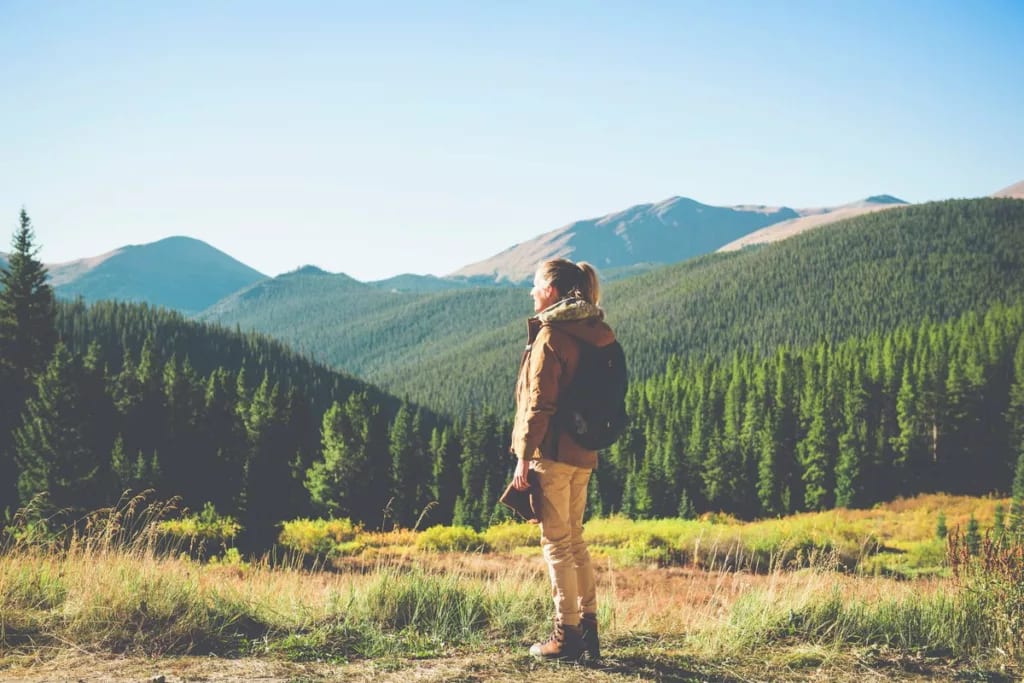hiker admiring view of mountains and trees cP.width .jpg