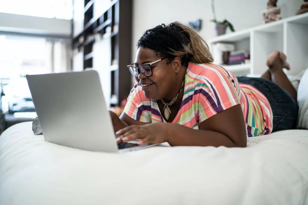person on bed with laptop Hpu.width .jpg