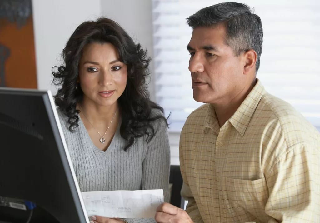 Couple holding a document and looking at a co.width kcHOJq.jpg