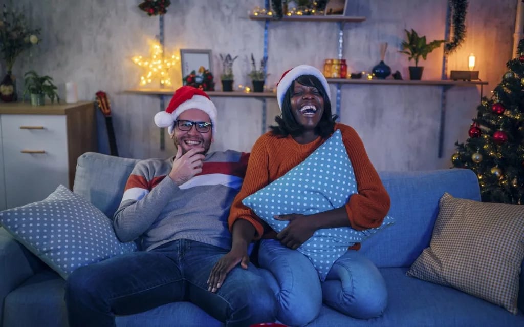 Couple in Santa hats watching a movie on the .width .jpg