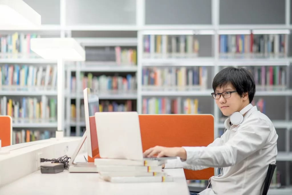 Male college student library laptop books tZT.width .jpg