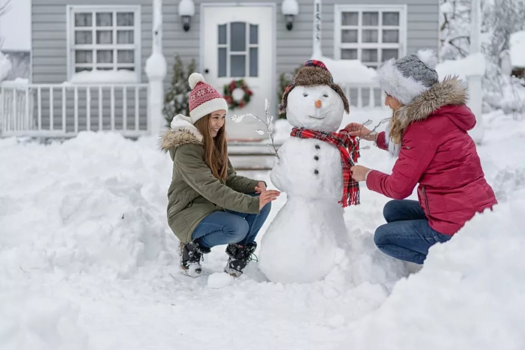 Mother and daughter building snowman in snowy.width itVQhwu.jpg