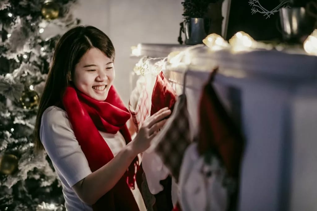 Woman hanging Christmas stocking over firepla.width .jpg