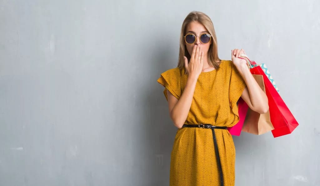 Woman holding shopping bags hand over mouth j.width .jpg