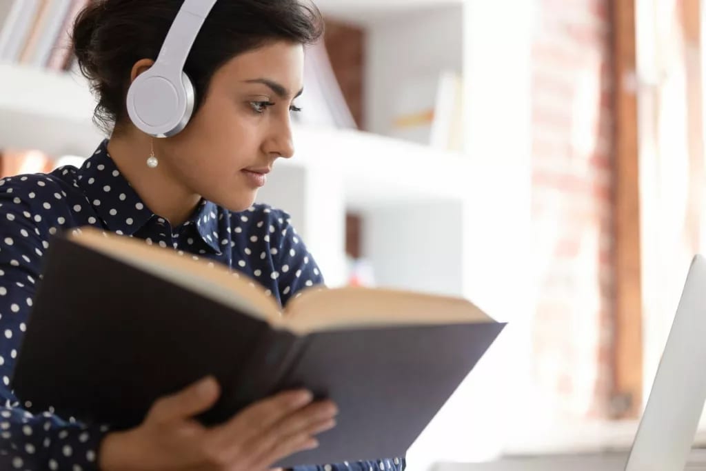 Woman looking up information in a book UQEKk.width .jpg