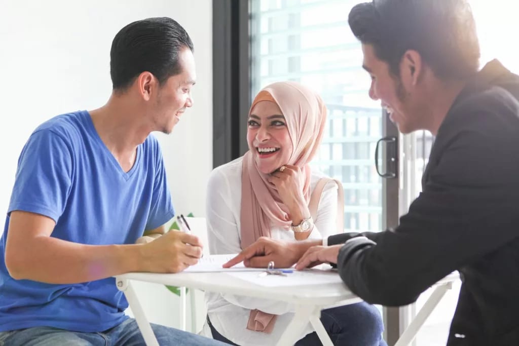 Young couple signs paperwork with agent TTMv.width .jpg