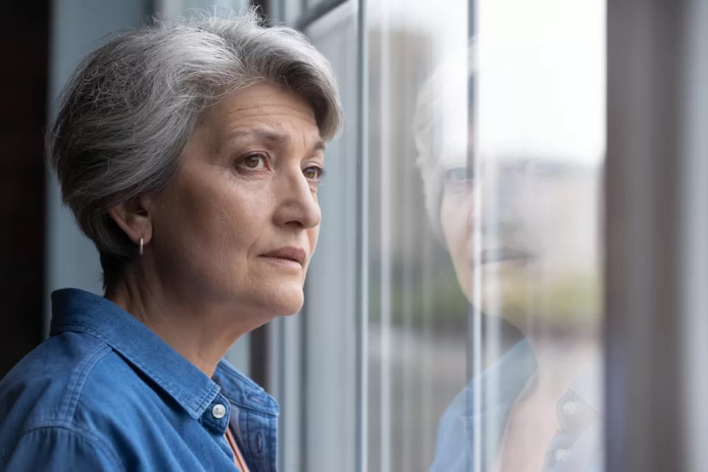 gettyimages worried senior woman looking out window.jpeg
