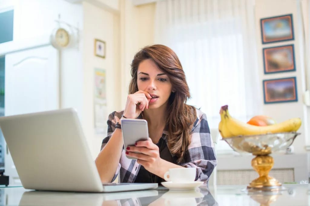 nervous young woman with phone and laptop.width .jpg