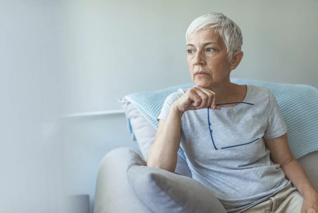 person sitting in a chair holding eyeglasses.jpg