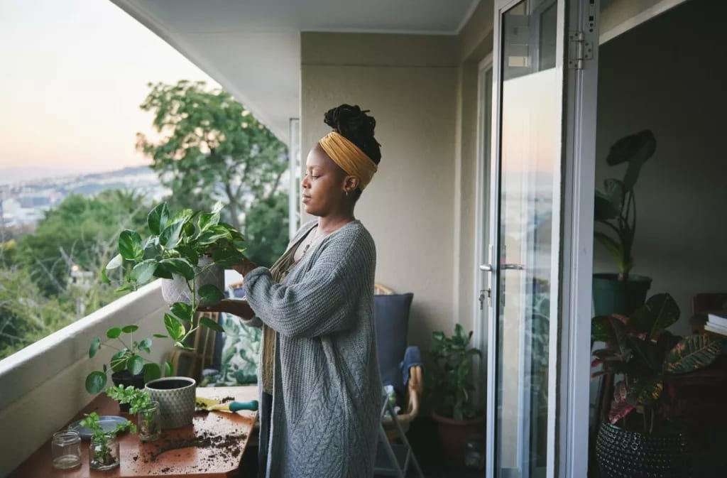 person with plants on balcony WBfBkd.width .jpg