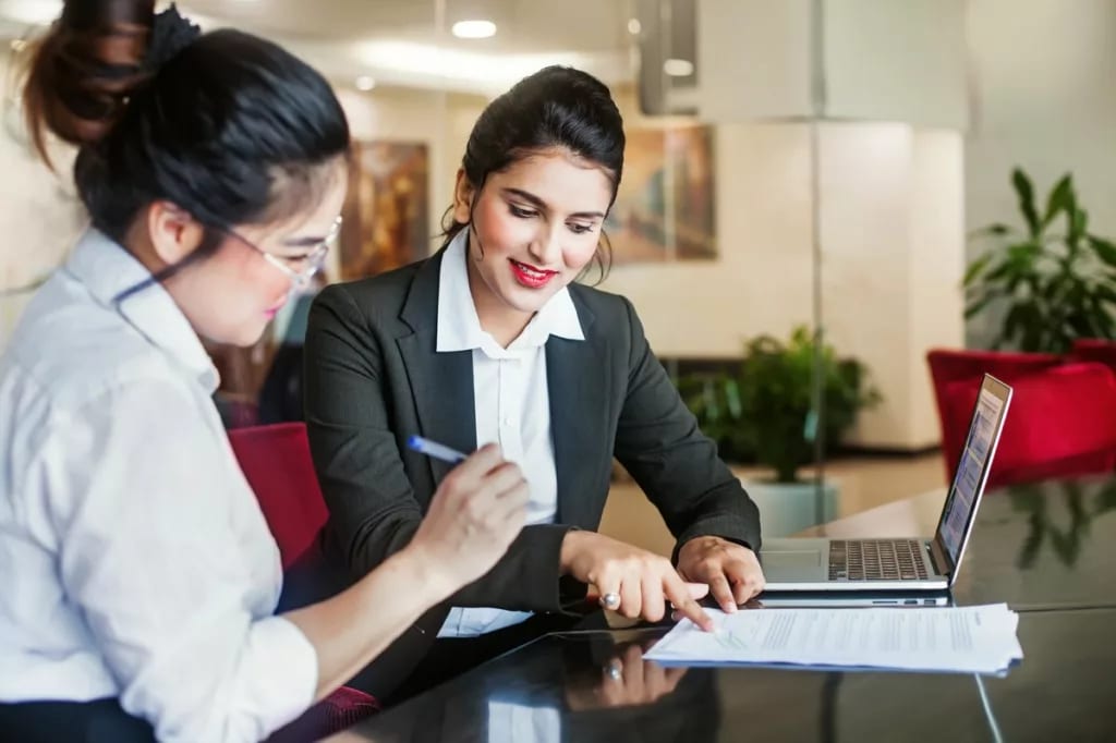 Bank employee and customer signing documents .width uzIxQD.jpg