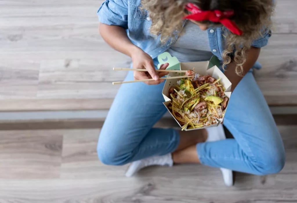 Getty woman eating takeout.width .jpg
