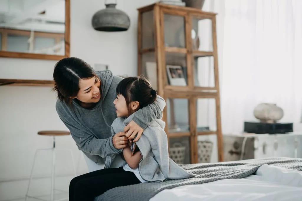 Mother wrapping blanket around young daughter.width wZbBjIn.jpg