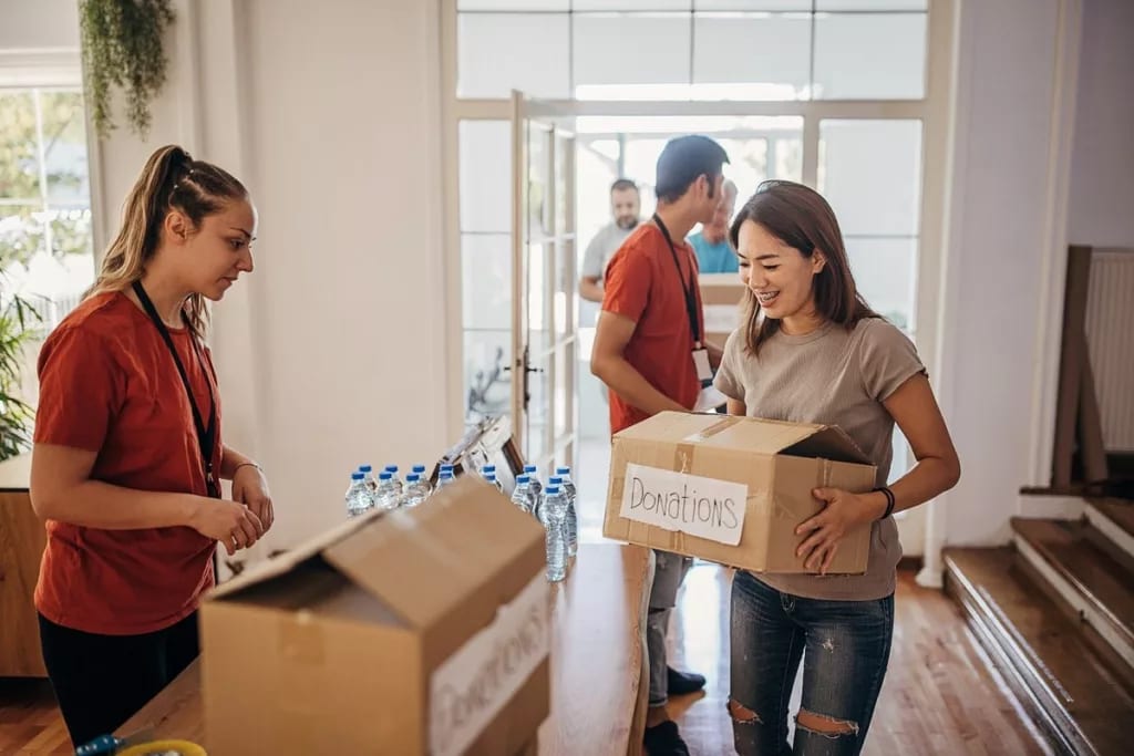 Woman carrying box marked Donations gPzKqVh n.width .jpg