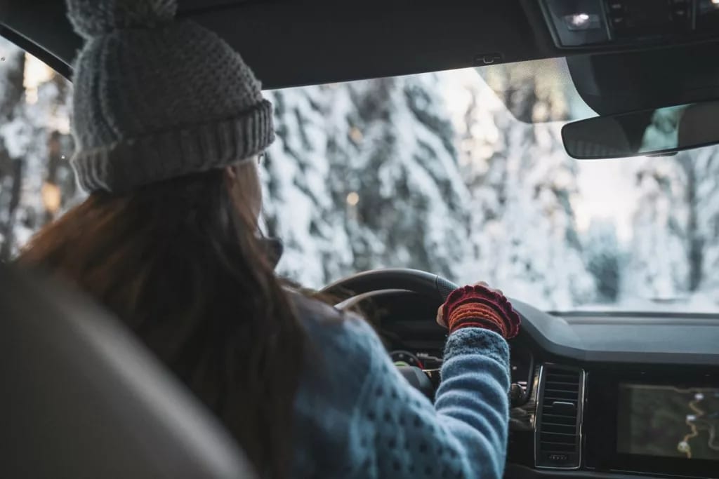 Woman in cold weather accesories driving a ve.width .jpg