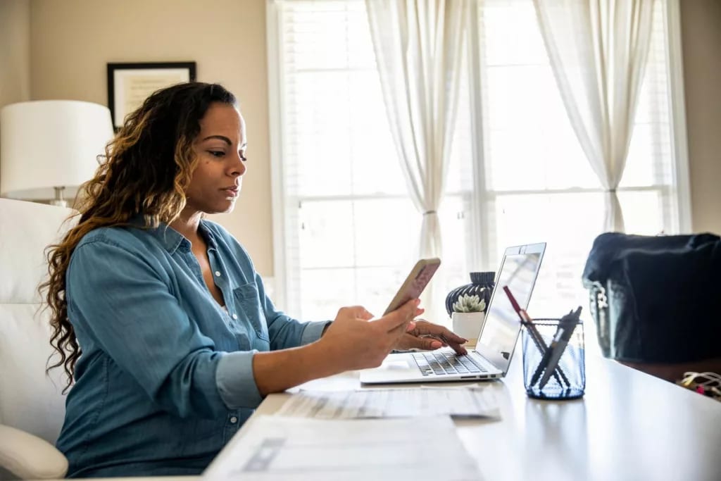 Woman using laptop and smartphone at home ToP.width .jpg