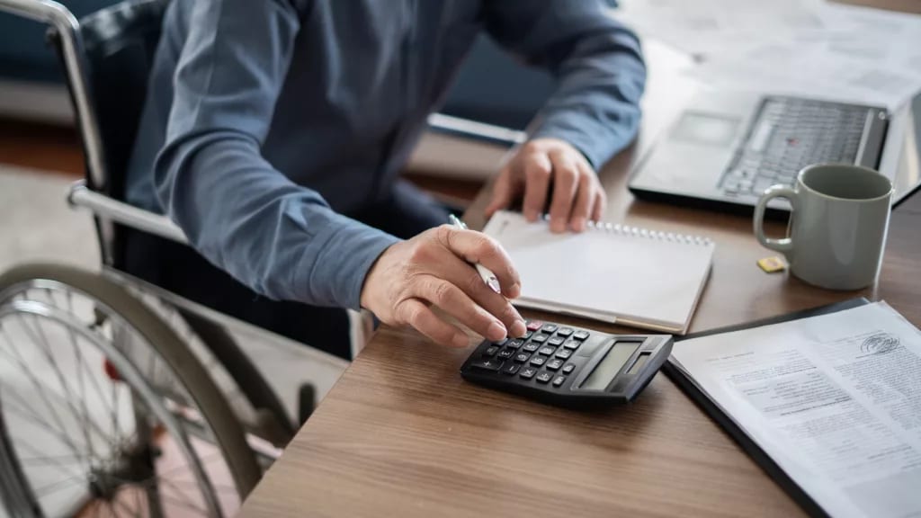 man in wheelchair calculating investments.jpg