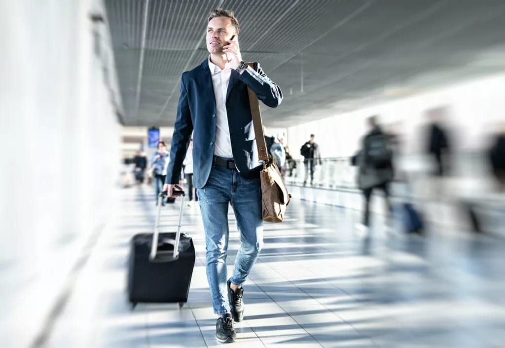 man in airport with suitcase and on the phone.width .jpg