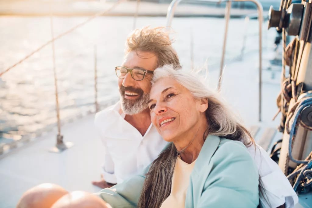 mature couple sitting on a boat smiling.jpg