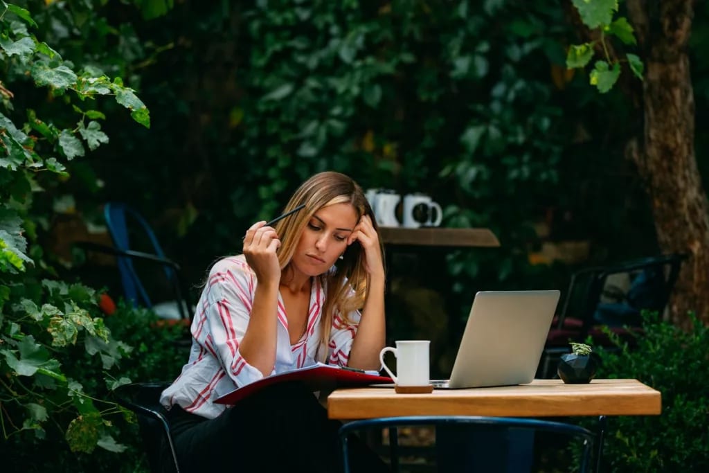 woman outdoor cafe with laptop and notebook.width .jpg