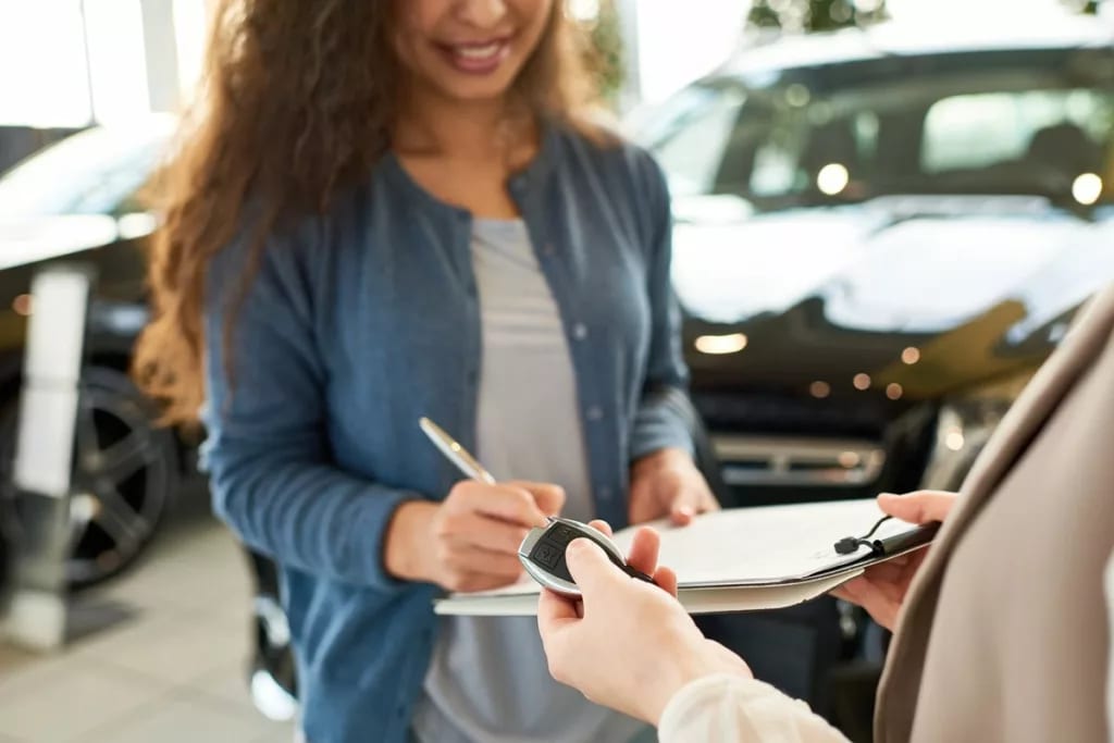 woman signing car paperwork xpccuHh.width .jpg
