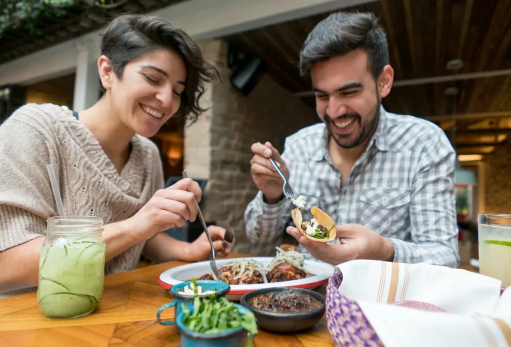 Couple sharing a meal in an outdoor space. Ae.width .jpg