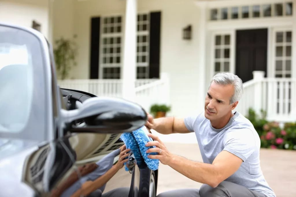 Man waxing his car in front of house RoiGJoP.width .jpg
