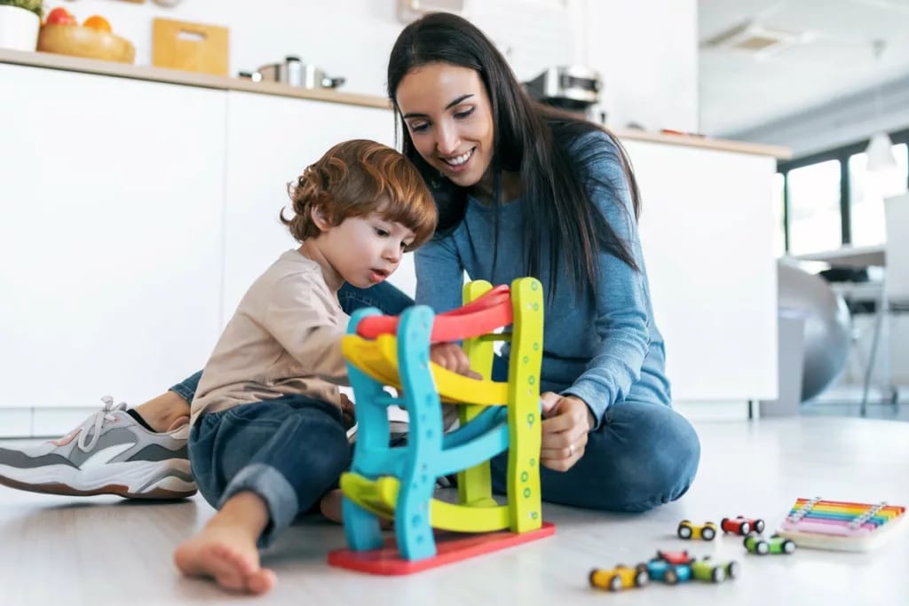 Mother and young son play with car toys toget.width .jpg