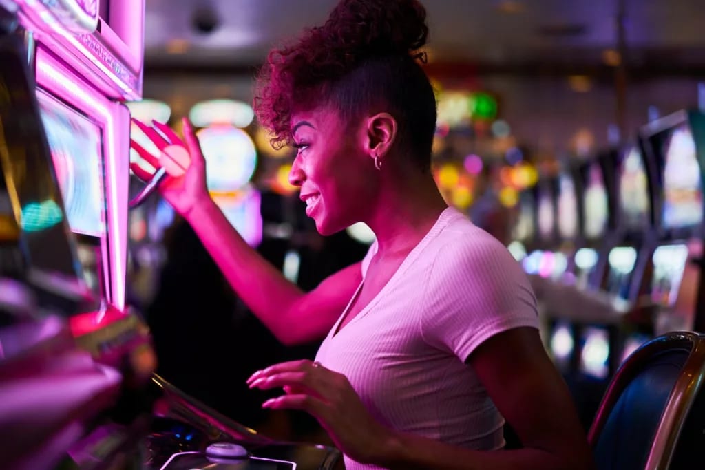 Person smiling while using slot machine in a .width .jpg