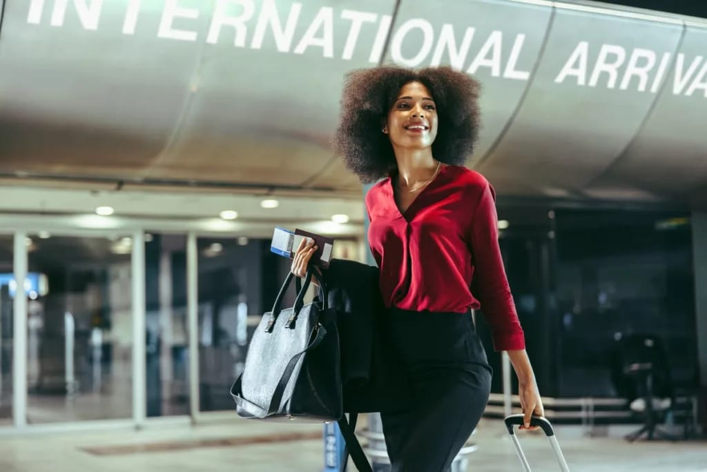 Smiling traveler walks through airport with l.width .jpg