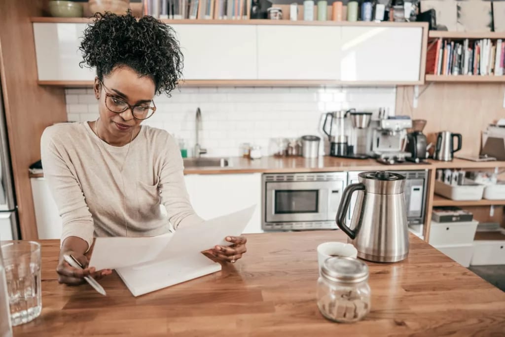 Woman sits in kitchen looking over personal f.width DSfPgo.jpg